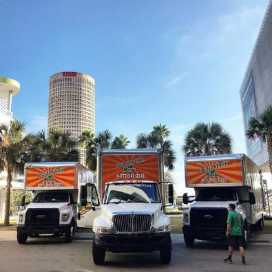 College HUNKS moving trucks with Downtown Tampa in the background.